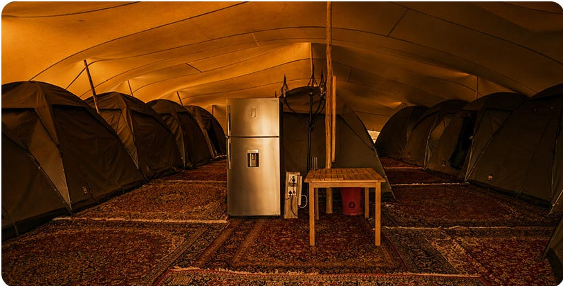 Dome tents beneath a stretch canopy